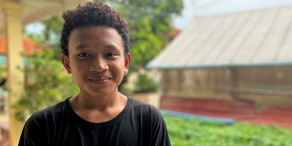 Makarana smiling in front of the garden at the home