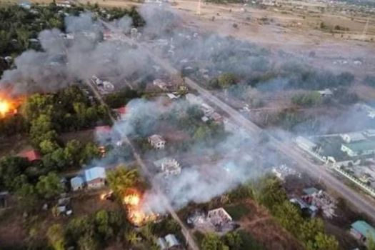 Ariel shot of a village burning