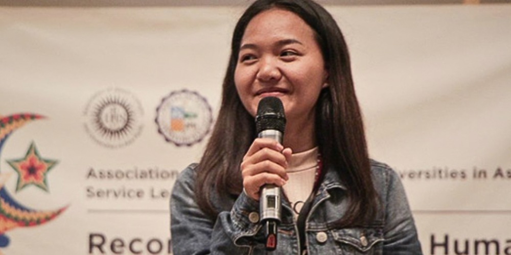 Toon holding a microphone presenting to a crowd