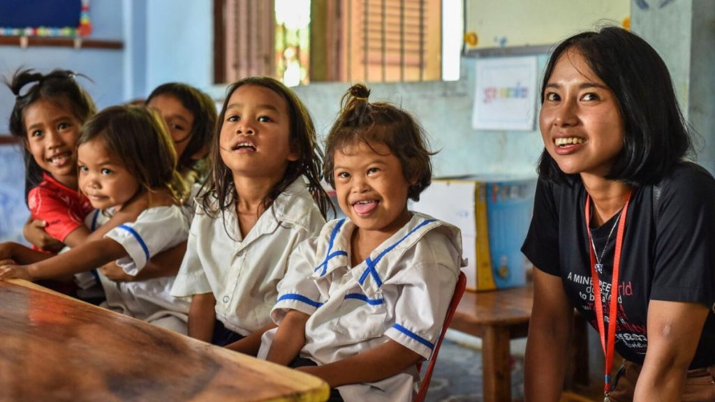Children laughing in the classroom with their teacher