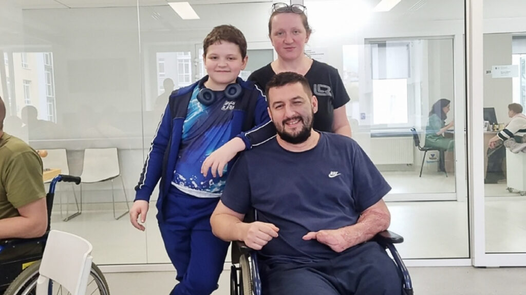 David in his wheelchair with his family standing beside him