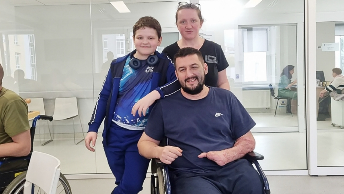 David in his wheelchair with his family standing beside him