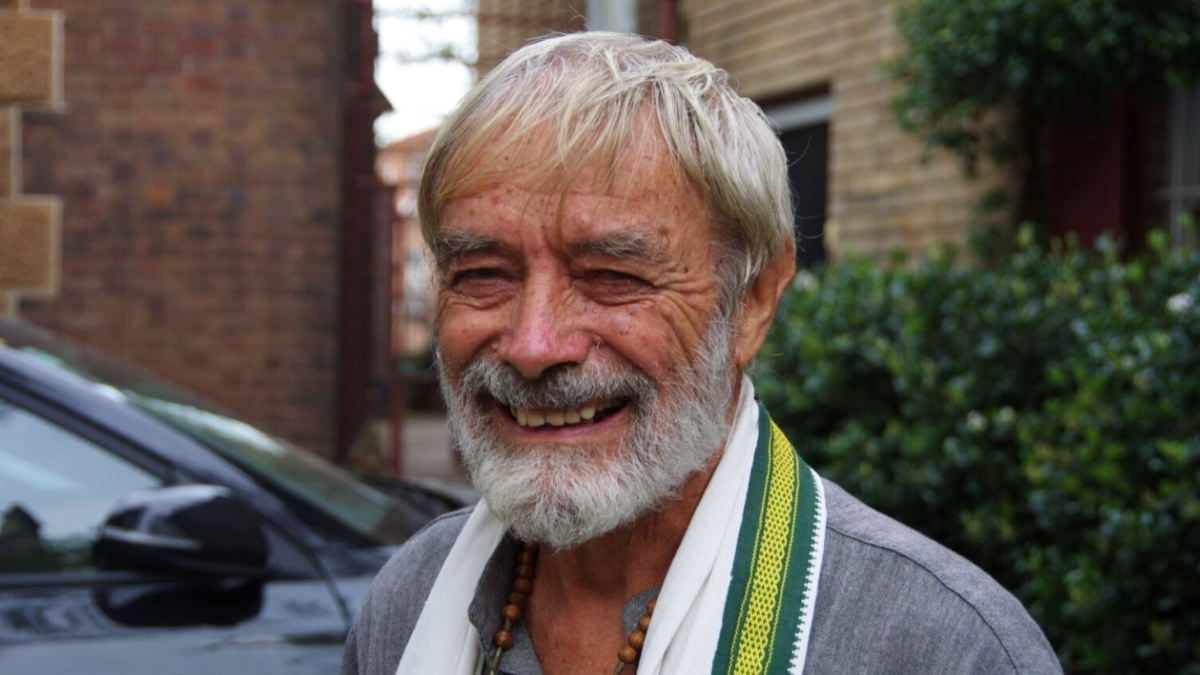 Father Bob smiling to camera in front of our offices
