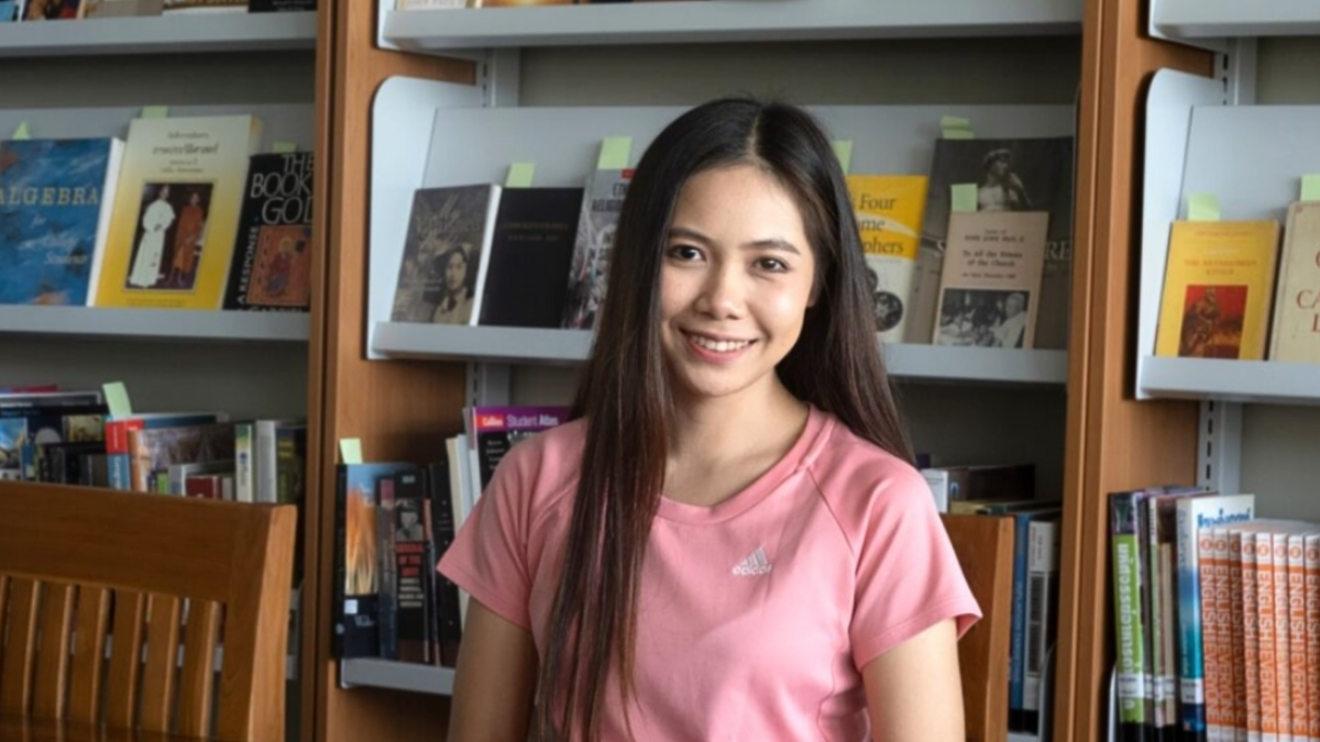 Wassana sits at a desk in the school library