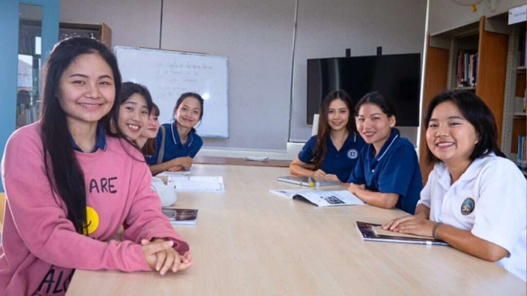 Wassana and her classmates sitting around a table in the library