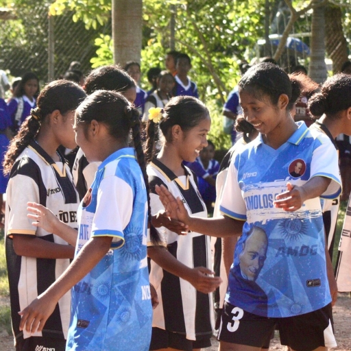A team of girls laughs and plays at the sports day