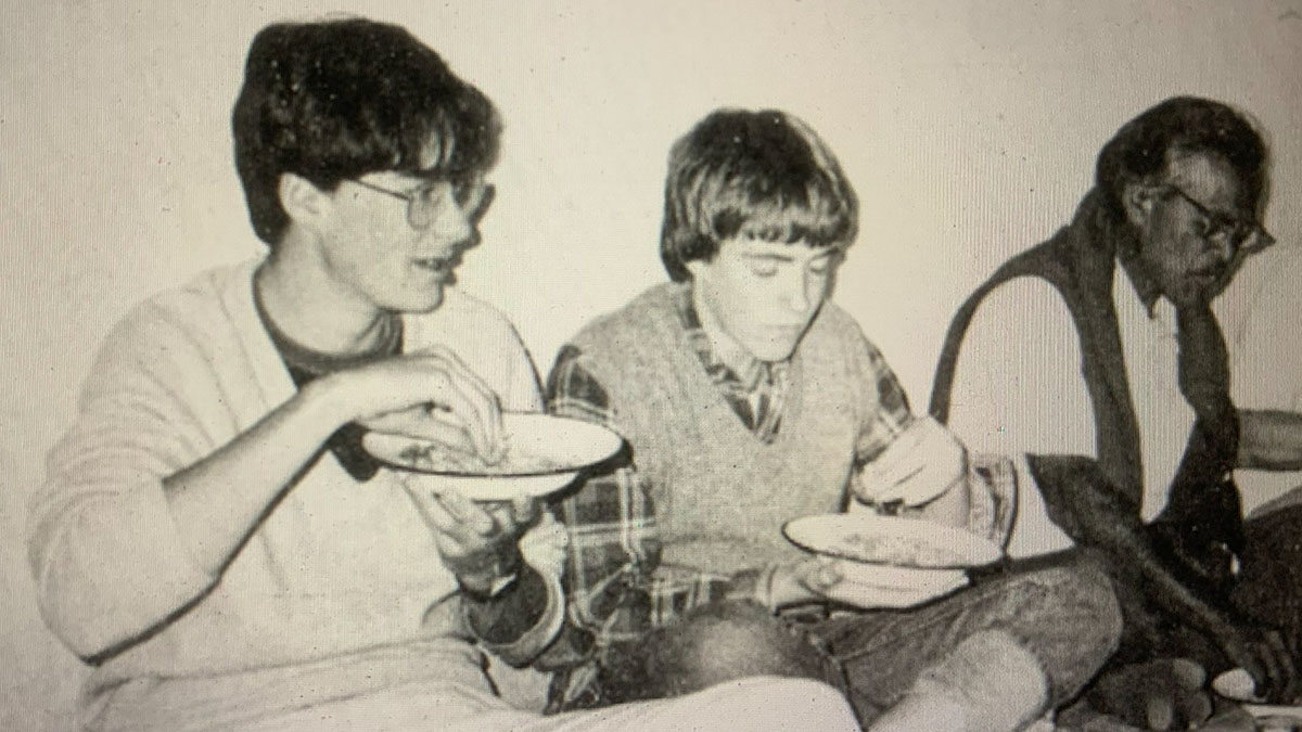 David and Grant sitting on the floor eating with locals in India