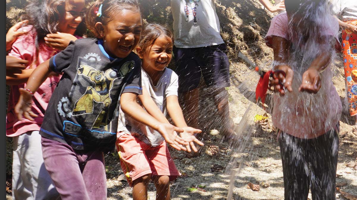 Children playing with clean water from a newly installed water tank