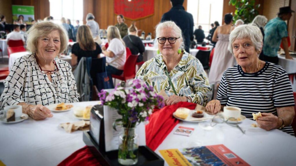 The 3 sisters having scones and tea at a table