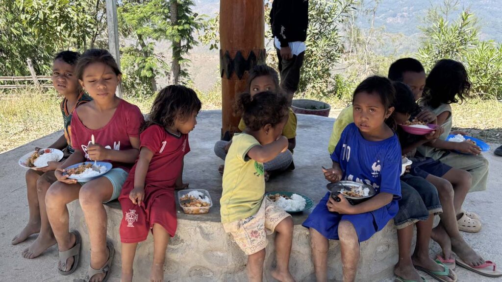 Kids sitting under a pergola enjoying their lunches